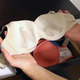 A woman holding a bra.